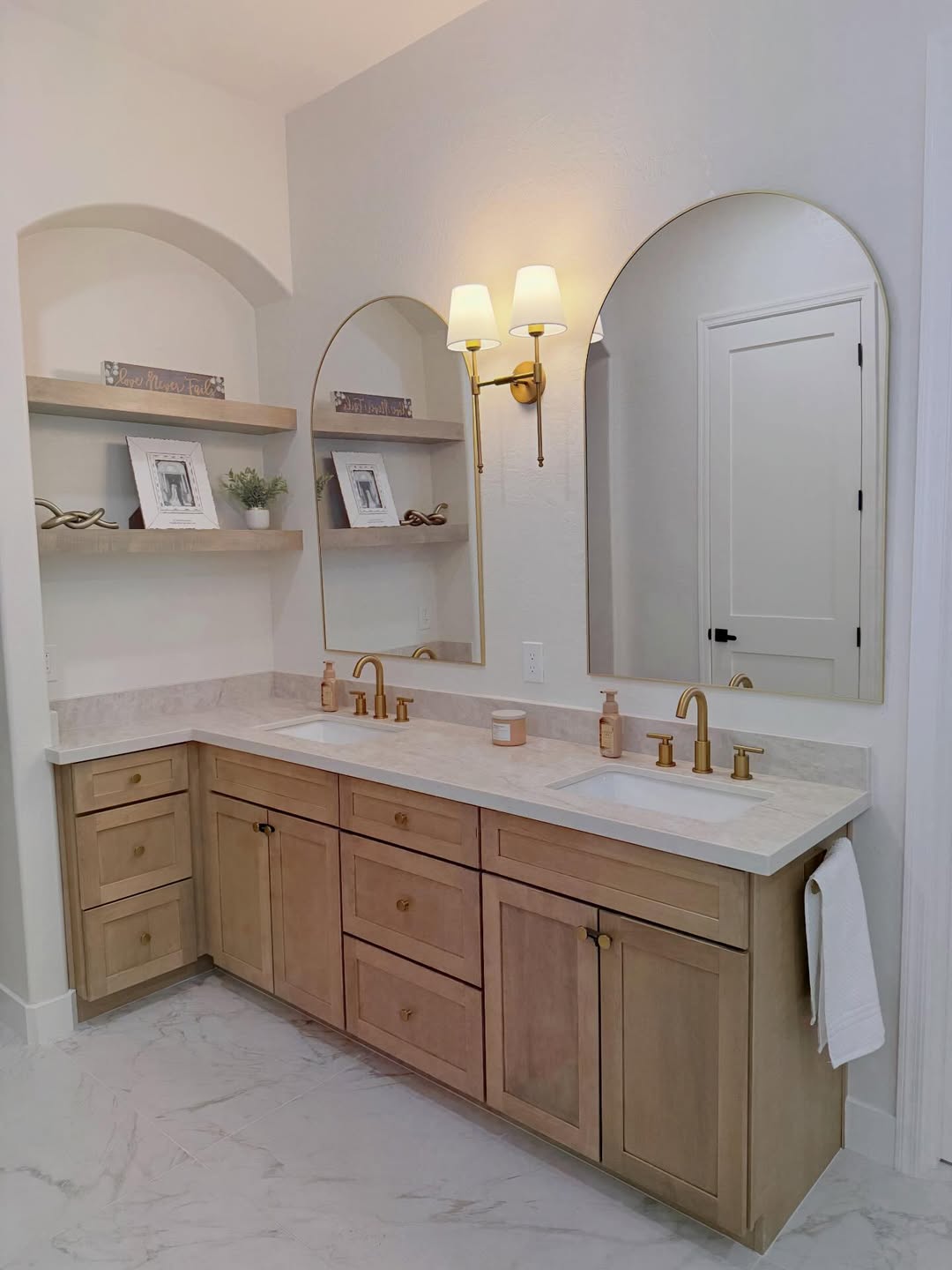 Double vanity with arched mirrors and built-in shelves